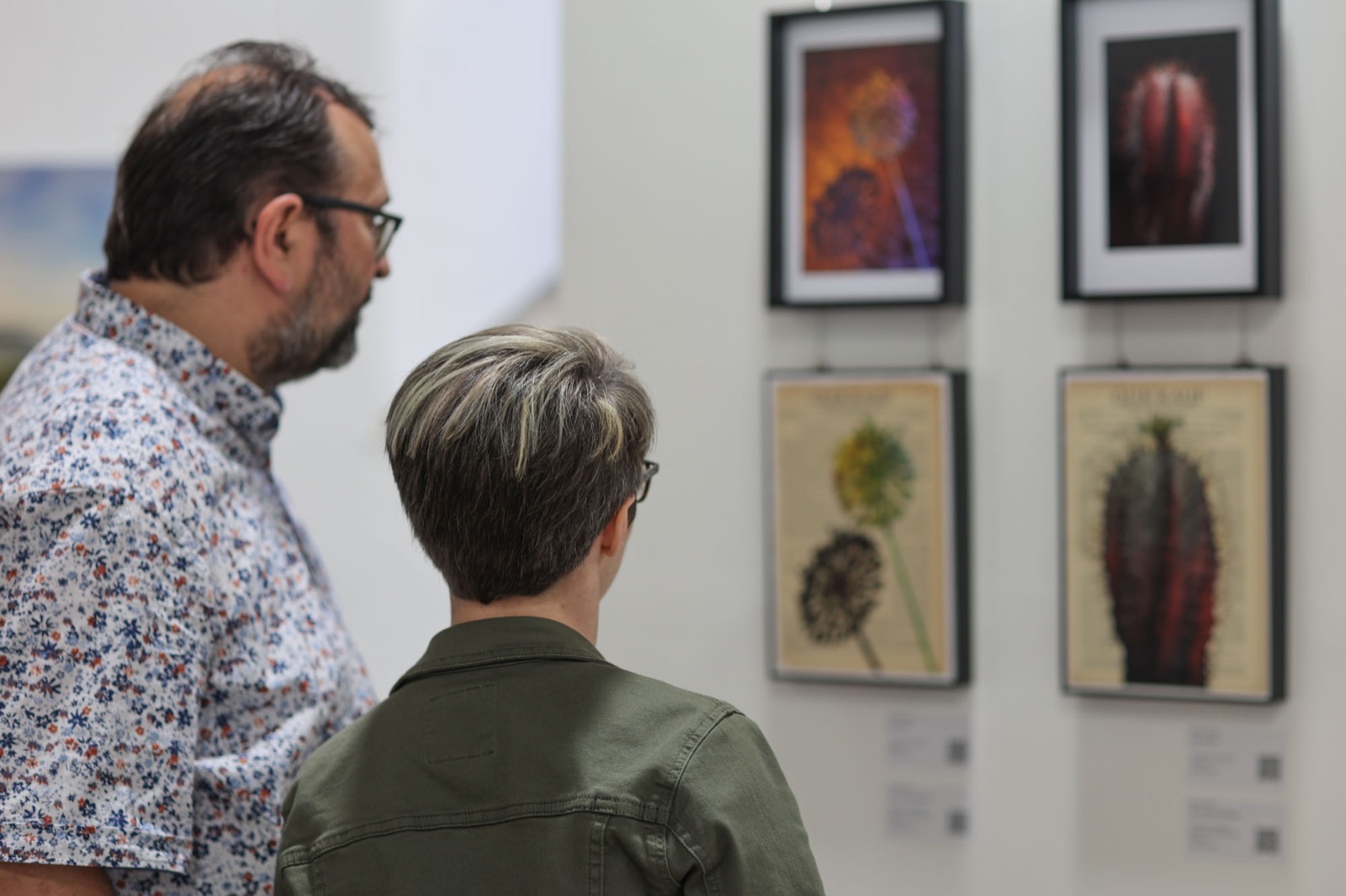 Gäste betrachten Fotografien in der Ausstellung